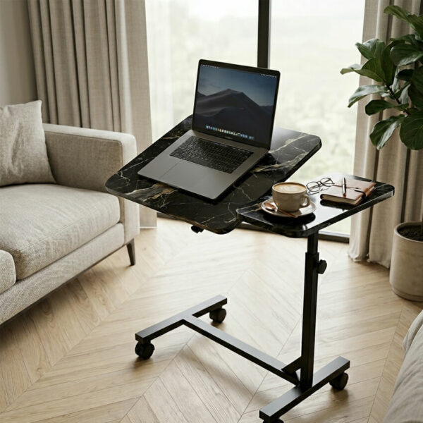 Table de lit roulante effet marbre noir dans un salon moderne, avec ordinateur portable sur plateau incliné et café sur plateau fixe.