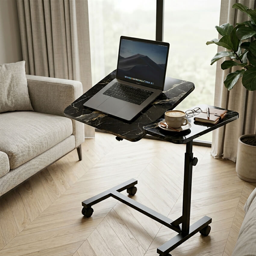 Table de lit roulante effet marbre noir dans un salon moderne, avec ordinateur portable sur plateau incliné et café sur plateau fixe.