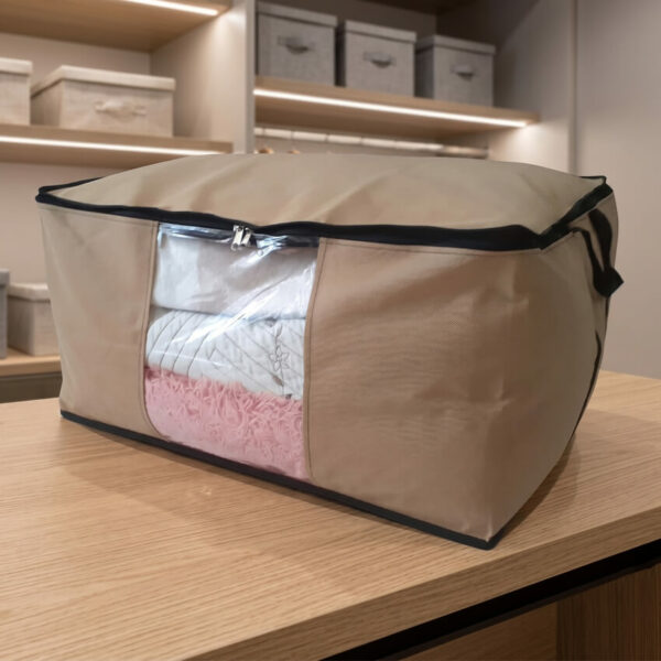 Sac de rangement premium grège avec fenêtre transparente contenant une couverture. Idéal comme sac rangement couette ou sac de rangement vêtement